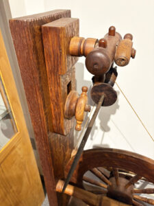 Close-up of movable board that holds short spindle post with spindle attached.